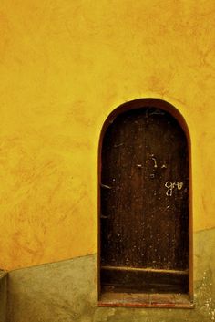 an open door on the side of a yellow building