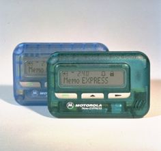 two electronic clocks sitting next to each other on a white surface with the time displayed