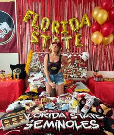 a woman sitting on top of a bed in front of a red and gold backdrop