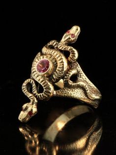 "Two fluid snakes entwine to form the Alpha-Omega Snake Ring. A 4.5 mm AA pink sapphire is bezel set between the two snakes. Rubies are set in the snakes eyes. The detailed ring is cast in 14K gold and lays 1 1/4\" lengthwise on the finger. Journey back into ancient times wearing this powerful serpent ring. Should we not have your size, please allow 2-3 weeks to custom make this ring for you. We will contact you to let you know when to expect shipment. All Marty Magic Jewelry is packaged in a be Antique Snake Ring As Gift, Gold Snake Ring Collectible Unique Style, Unique Gold Snake Ring Collectible, Antique Snake-shaped Yellow Gold Jewelry, Medusa Jewelry, Cleopatra Jewelry, Two Snakes, Magic Jewelry, Serpent Jewelry