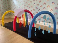 two play structures with rainbows and raindrops on the wall