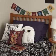 a bed with harry potter themed pillows on it and a lamp next to the headboard