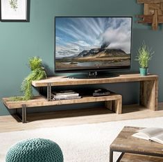 a flat screen tv sitting on top of a wooden stand in front of a green wall