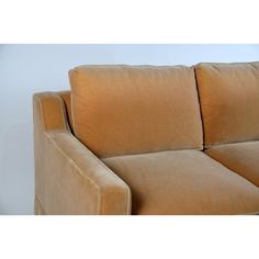 a tan couch sitting in front of a white wall