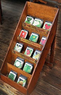 a wooden display case filled with cards on top of a wooden floor next to a table