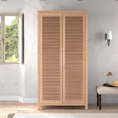 a large wooden cabinet sitting in the corner of a room next to a window with shutters