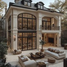 a large house with lots of windows and couches in front of the patio area