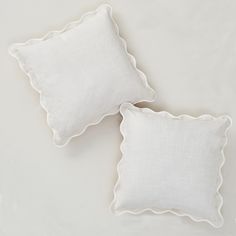 two white pillows with scalloped edges