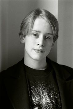 a black and white photo of a woman with short hair wearing a blazer over a t - shirt