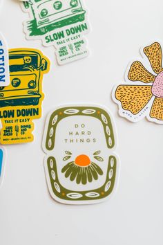 various stickers on a white surface including flowers, cars and busses with the words slow down