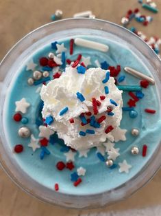 a cup filled with whipped cream and red, white and blue sprinkles