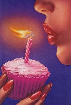 a woman blowing out a candle on top of a cupcake with pink frosting