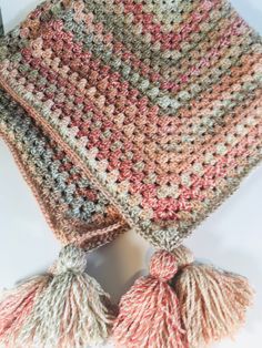 a crocheted scarf with tassels on it