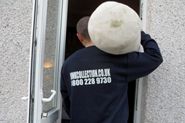 a man with a large white ball on his head standing in front of a door