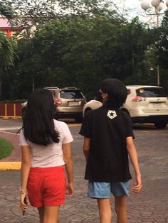 two people walking down the street with skateboards