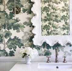 a white sink sitting under a bathroom mirror next to a wall mounted faucet