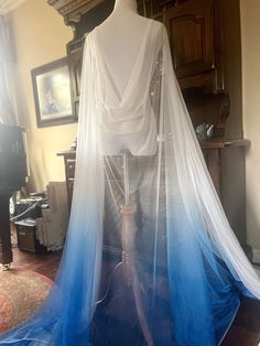 "Save yourself time and money by downloading your free \"Cape Guide\" by copying and pasting this link: https://mailchi.mp/7293feff861f/veilguide A brightly modern take on the classic wedding veil, this bold and bright blue, lovingly dyed cape veil was designed for unconventional brides who want to show off their fun personality.  Made from soft silk blend fabric, this detachable cape / veil can be work in many different ways. It easily secures to your gown with petite clips or I can attach smal White Flowy Wedding Dresses, Blue And White Wedding Dress, Water Costume, Veil Floor Length, Draped Veil, Soft Blue Dress, Wedding Cape Veil, Cape Veil, Blue Veil