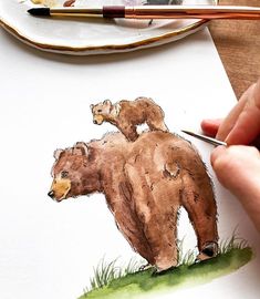 someone is painting a bear on paper with watercolors