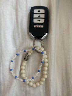 a white beaded keychain with blue beads attached to it