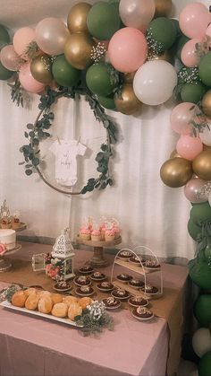 a table topped with lots of desserts and balloons