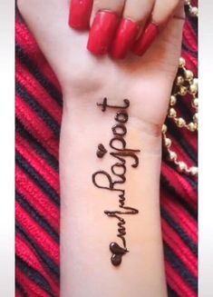 a woman's wrist with the words tattoo on it and her name written in cursive writing