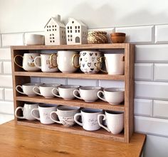 a wooden shelf filled with lots of coffee cups