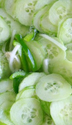 sliced cucumbers and onions in a bowl on a wooden cutting board, ready to be cooked