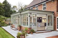 a house that has some plants in front of it and an open door on the outside