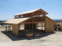 a large building sitting on top of a dirt field next to a bulldozer