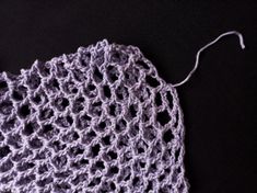 a crocheted piece of cloth on a black surface