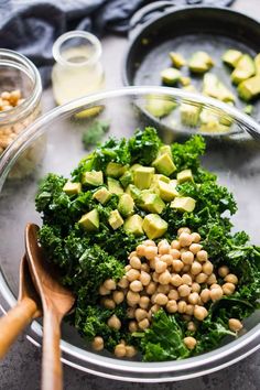 a salad with chickpeas, avocado and spinach in a bowl