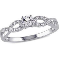 a white gold ring with an oval cut diamond surrounded by small round brilliant czrs