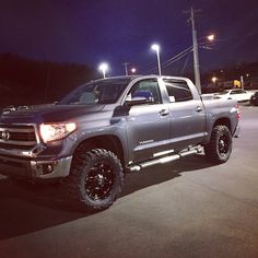 a silver truck parked in a parking lot at night