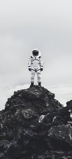 an astronaut standing on top of a rocky hill