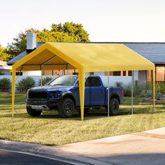 a blue truck parked under a yellow tent on the side of a road in front of a house