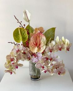 a vase filled with flowers on top of a white table