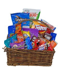 a wicker basket filled with snacks and candy bar wrappers, including chips, bars, and more