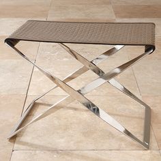 a metal table sitting on top of a tiled floor