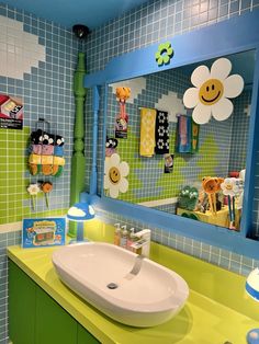 a bathroom with a sink, mirror and toys on the wall