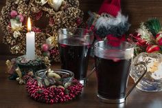 a candle is lit next to a glass of liquid and some decorations on the table