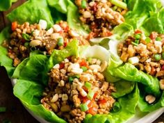 lettuce wraps filled with meat and veggies on top of a white plate