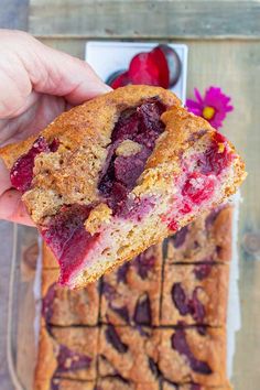 a hand holding up a piece of bread with cranberry sauce on it and the text overlay reads, breakfast plum cake gluten - free