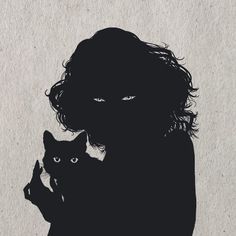 the silhouette of a person holding a cat in front of a white wall with black writing on it