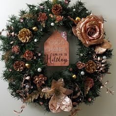 a christmas wreath hanging on the wall with a sign that says welcome home for the holidays