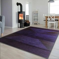 a living room with a purple rug on the floor and a wood burning stove in the corner