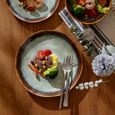 three plates with different types of food are on a table next to silverware and flowers