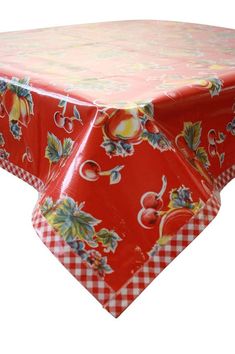 a red and white table cloth with an image of flowers on it, sitting on top of a checkered tablecloth