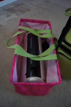 a pink and green suitcase sitting on the floor next to a black and white bag