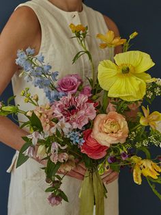 a woman holding a bouquet of flowers in her hands