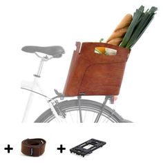 a bicycle with a leather bag attached to the handlebars and some vegetables in it